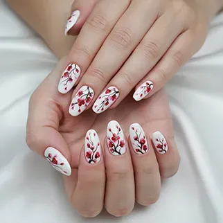 A close-up of hands with white almond-shaped nails, each decorated with an intricate red and dark red floral pattern
