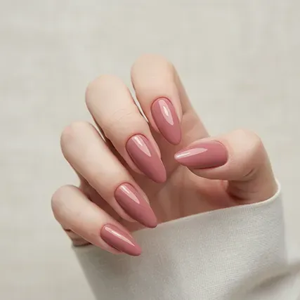 Hand with medium length, elegant gel x nail extensions solid pink color.